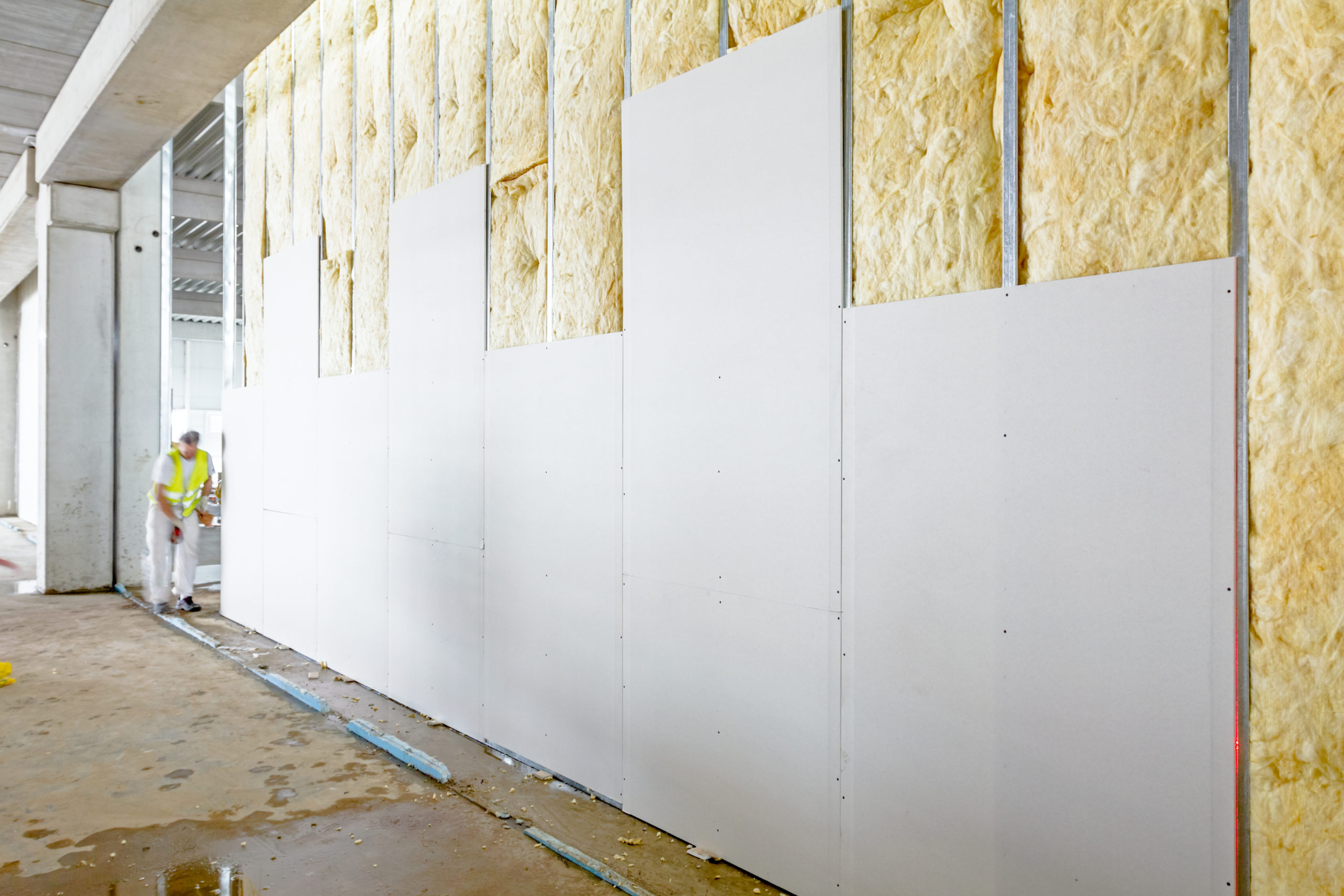 Front view of gypsum wall, plasterboard is under construction View at unfinished thermal partition dry wall with mineral wool.
